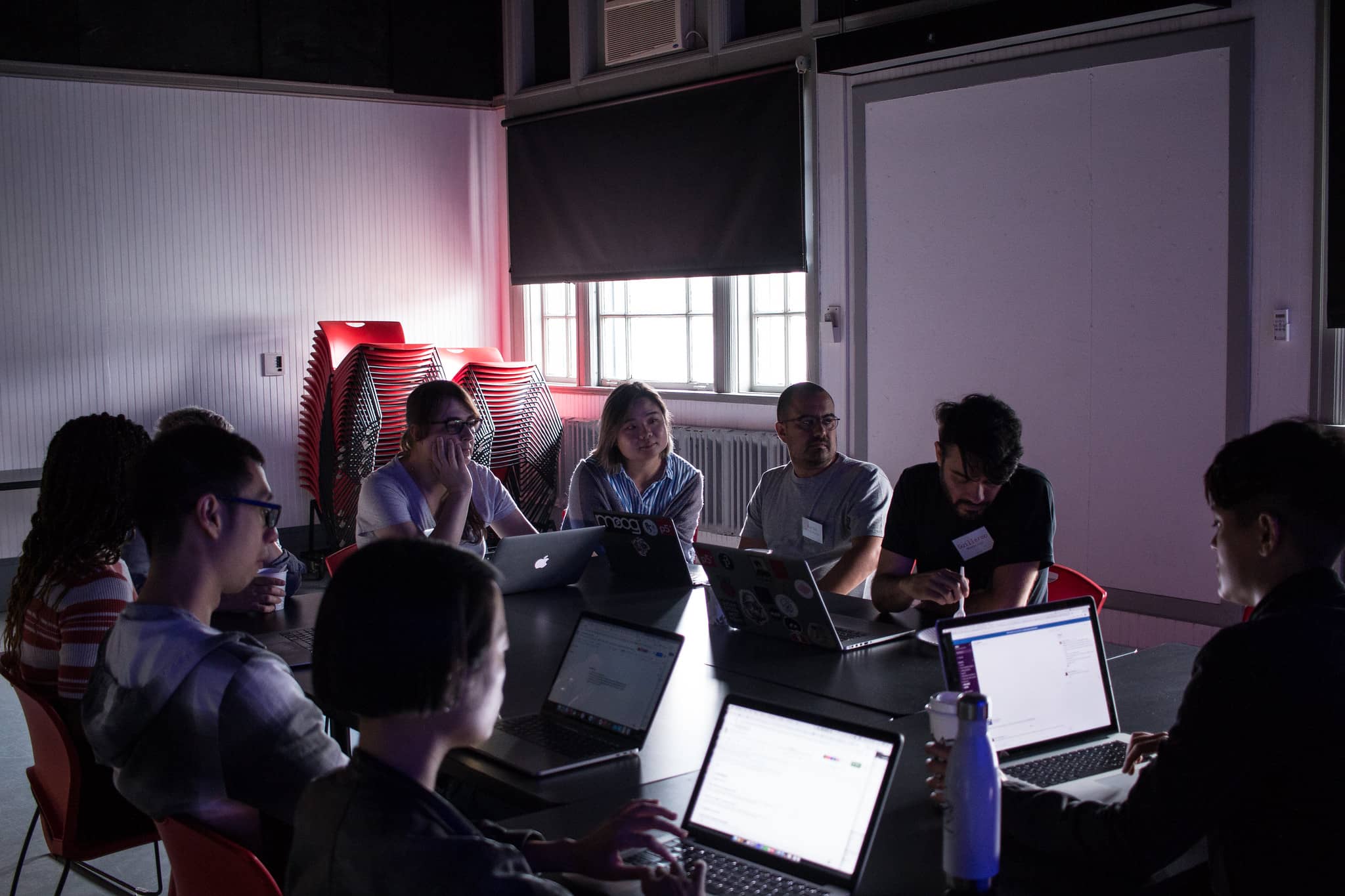 Participants in a meeting in a dark classroom"